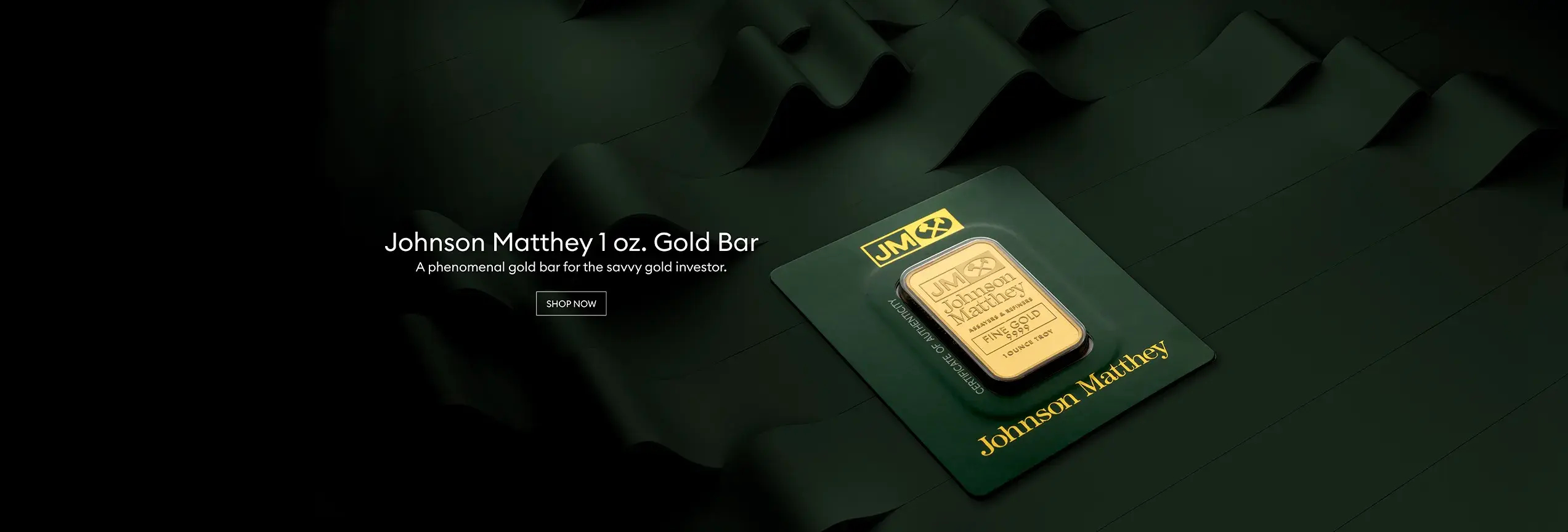 A Johnson Matthey 1 oz gold bar in it's packaging on top of dark green siky ribbons in a dark background.